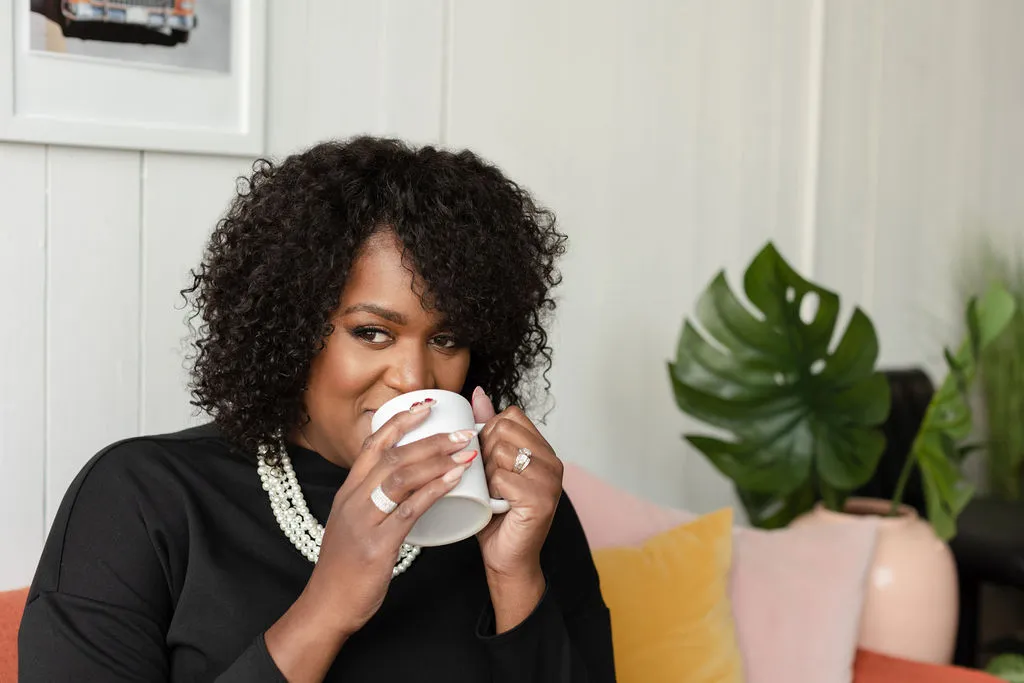 Dr. Keisha Scarlett seated with a cup of coffee