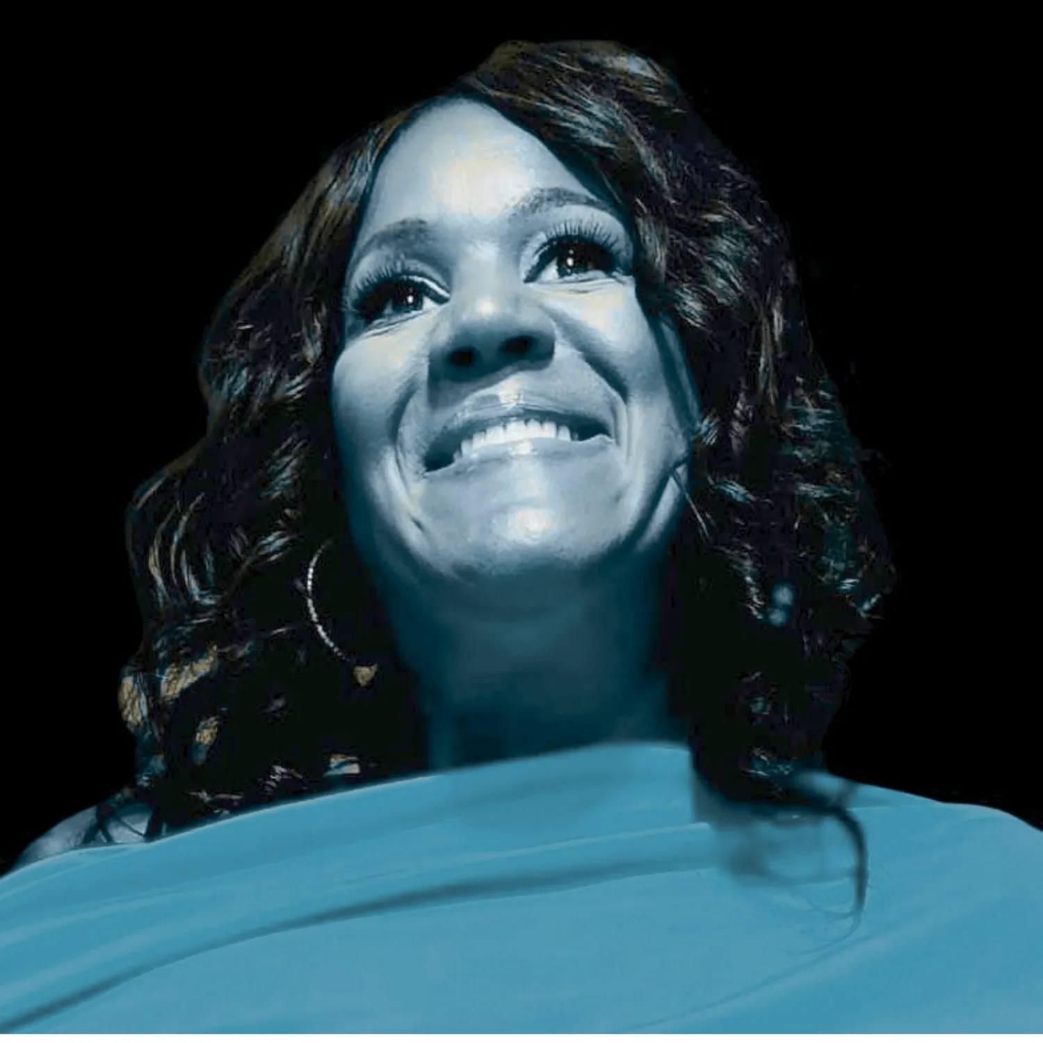 Dr. Keisha Scarlett looking upward in cyan-toned light
